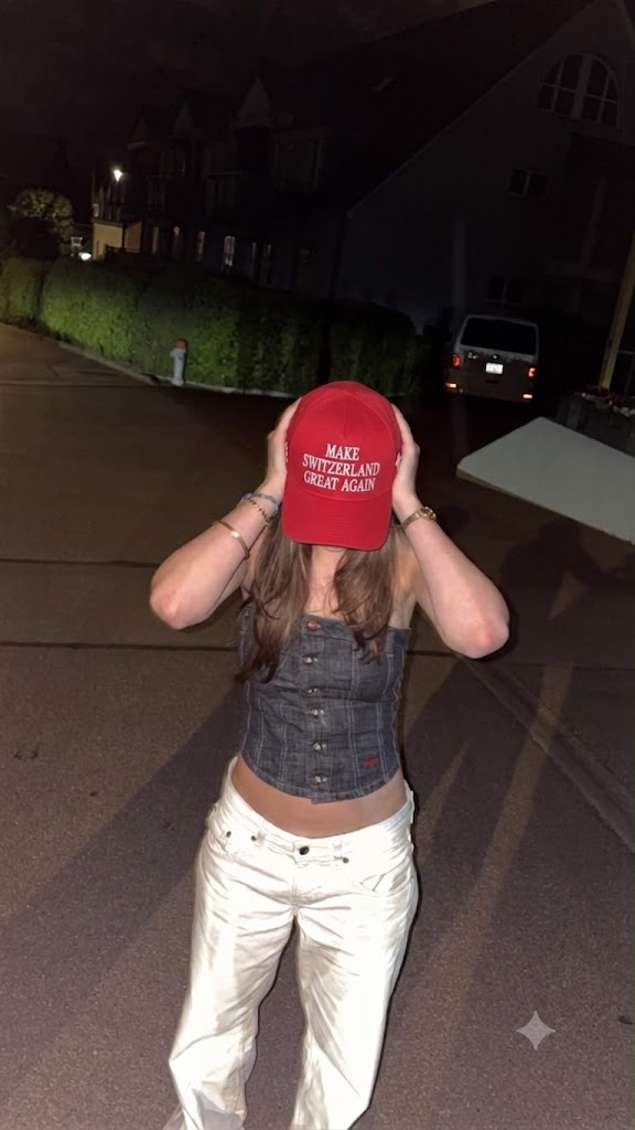 Man wearing the Make Switzerland Great Again cap at night by a monument